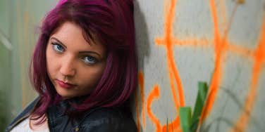 teen girl standing against a wall