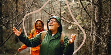 Woman hiking in nature, as it rains, embracing the weather
