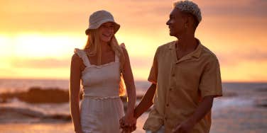 couple holding hands walking on the beach