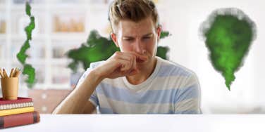 Man covering his nose due to stinky classroom