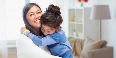 smiling mom and daughter hugging