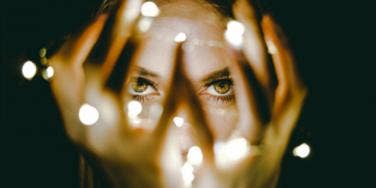 woman with lights tangled in fingers