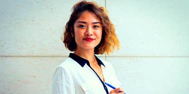 Young Asian professional woman standing confidently and smiling at the camera 