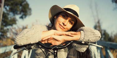 Spiritual woman looks content in hat