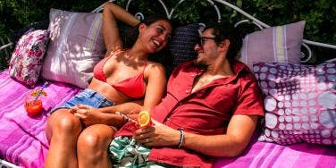 woman and man cuddling on picnic blanket
