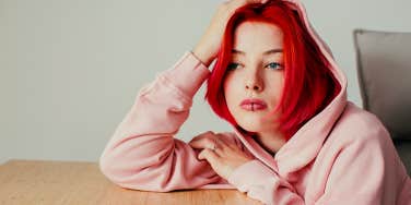 young woman stressed leaning on a table