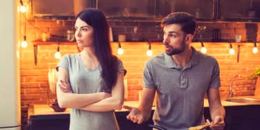 man trying to talk to woman with crossed arms looking in other direction