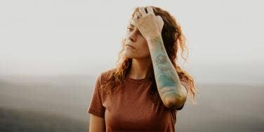 woman with tattoo with hand in hair