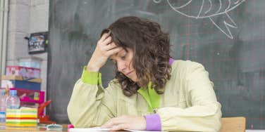 frustrated, sad teacher sitting at her desk