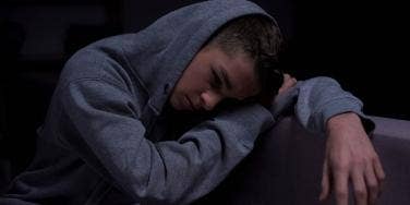 moody photo of teenager in hoody