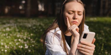 woman with upset face reading phone