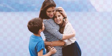 a mom embracing her young kids