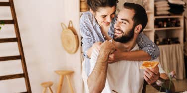 Couple sitting at breakfast table having a sweet moment, hugging