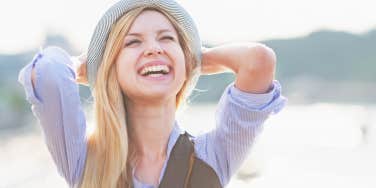 young blonde woman smiling in hat