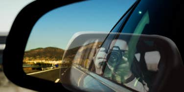 Woman taking photo of herself and the road behind her 