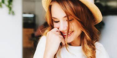 glowing young woman with red hair and hat