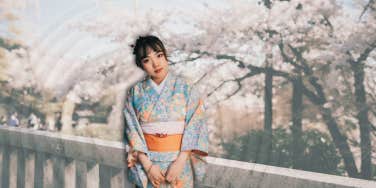 Japanese woman in front of cherry blossoms 