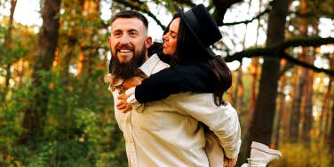 man carrying woman on his back