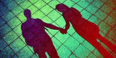 man and woman holding hands against green background