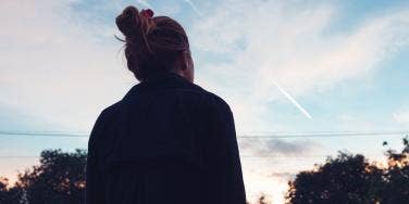 woman in shadow looking at sky