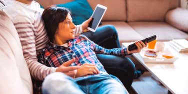 man and woman laying on a couch