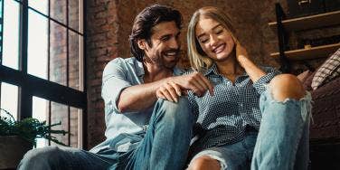 man and woman in jeans laughing together