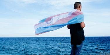 man standing near lake with flag