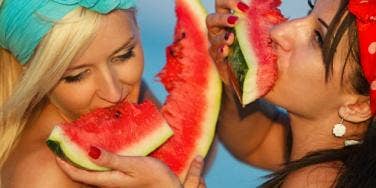 two women eating watermelon