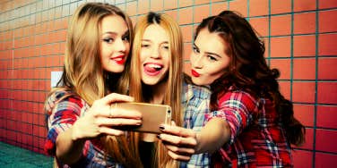 three girls taking a selfie in a bathroom