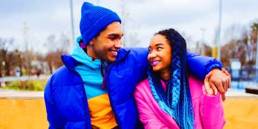 man with arm around woman