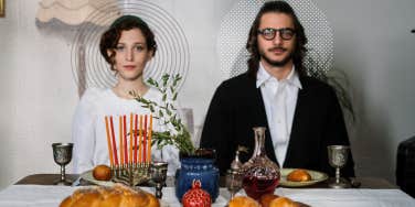 Couple sitting at a dinner table, not speaking staring straight ahead