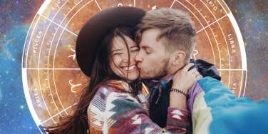 couple kissing in front of planet venus and zodiac wheel