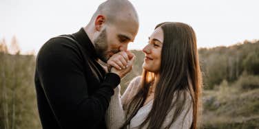 man kissing woman's hand