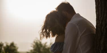 man hugging woman from behind