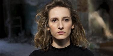 woman with stoic expression looking directly at camera