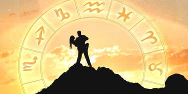 silhouette of couple on top of mountain and astrology wheel