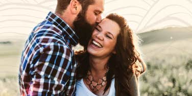 Woman being loved on by partner, smiling 