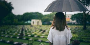 woman in cemetery with umbrella