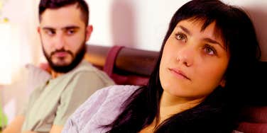 couple sitting in bed unhappy