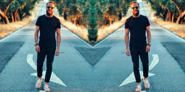 mirrored image of smiling man walking on a street toward the camera