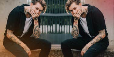 man sitting on railing outside