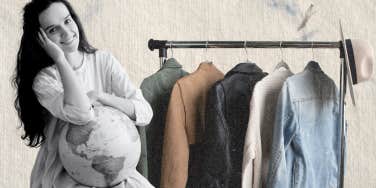 Woman holding a globe in front of a small rack of clothes