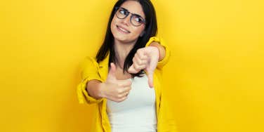 young brunette woman with thumbs up and thumbs down