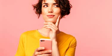 woman holding cellphone wondering what to say to a guy on Tinder