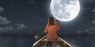woman moving toward full moon