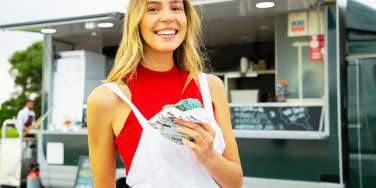 single woman eating a donut smiling