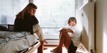 unhappy couple sitting in bedroom