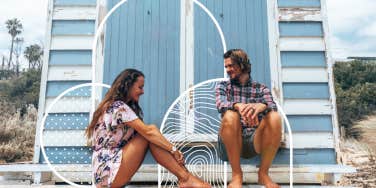 Couple sitting on beach lifeguard stand