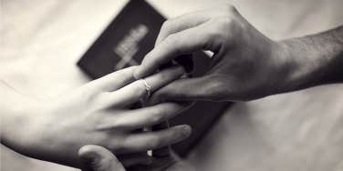 man putting ring on wife's finger