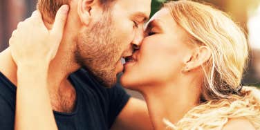 Young couple deeply in love sharing a romantic kiss, closeup profile view of their faces